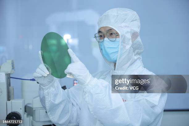 An engineer checks an 8-inch silicon carbide polished wafer at a workshop of Zhejiang Jingsheng Electromechanical Co., Ltd. On February 9, 2023 in...