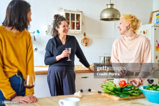 fröhliche freundinnen kochen gerne in der küche zu hause - wein und kochen stock-fotos und bilder