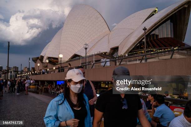People wearing masks walk outside The Sydney Opera House on a Friday night on February 10, 2023 in Sydney, Australia. On July 6, 2022 the Australian...
