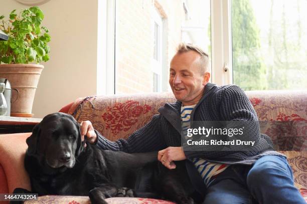 mature man stroking his black labrador dog - labrador retriever stock pictures, royalty-free photos & images