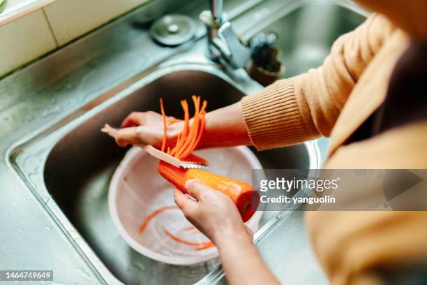 a middle-aged woman washed organic vegetables and carrots for lunch - healthy lifestyle, family life - damaged skin stock pictures, royalty-free photos & images