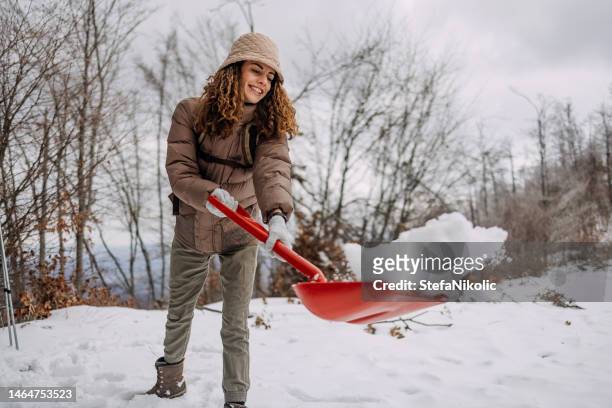 woman cleans the snow - winterdienst stockfoto's en -beelden