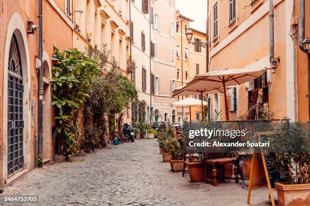 alley with restaurants in trastevere district, rome, italy - zuid europa stockfoto's en -beelden