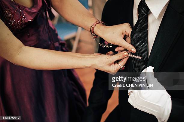 woman putting tie pin - tie pin stock pictures, royalty-free photos & images