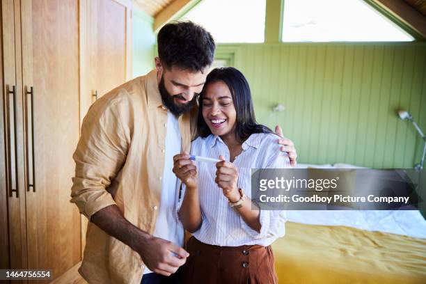 ecstatic couple waiting for the results from a home pregnancy test - family planning stock pictures, royalty-free photos & images