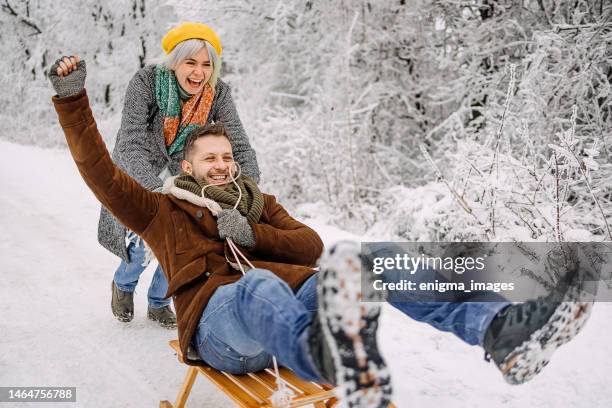 fun couple on a sled - sled push stock pictures, royalty-free photos & images