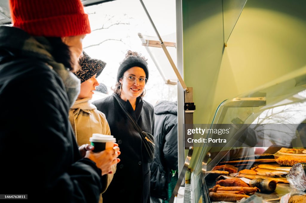 Group of women friends at food truck in flea market