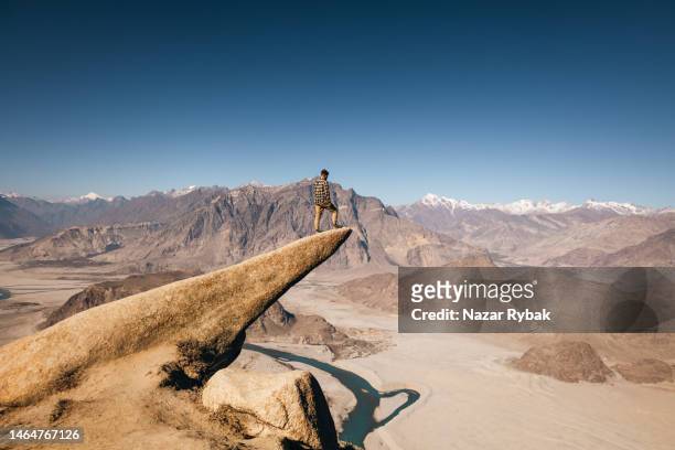 der männliche reisende auf dem marsur rock mit blick auf die malerische aussicht auf den indus - indus river pakistan stock-fotos und bilder