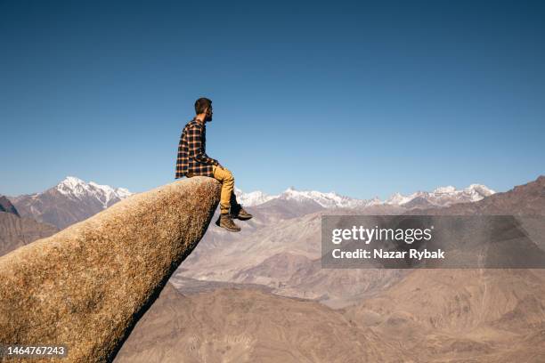 The male traveler sitting at the edge of the cliff in the Marsur Rock