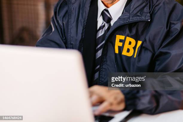 fbi detective using laptop in his office - fbi agent stockfoto's en -beelden