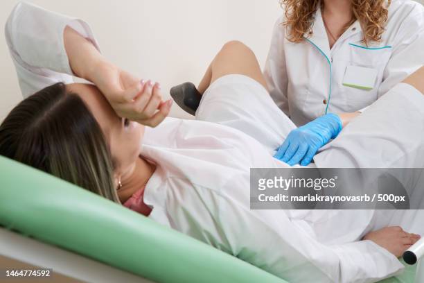 gynaecologist examining a patient sitting on gynecological chair - patientin stock-fotos und bilder