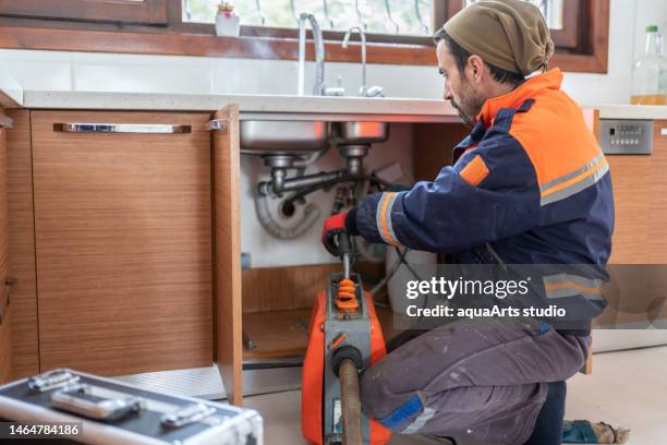 台所の流し排水管の詰まりを取り除く配管工 - 閉塞 ストックフォトと画像