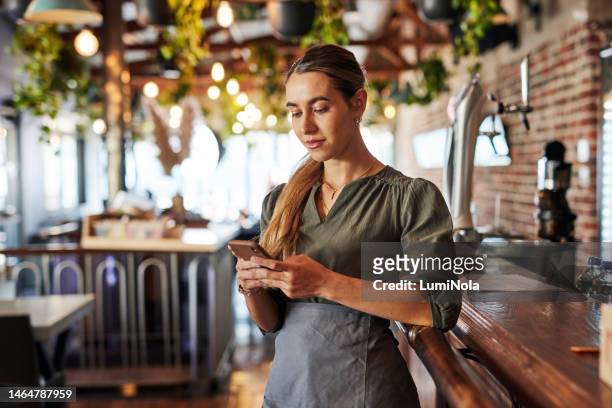 phone, bartender or small business woman for communication, networking or online blog content reading. research, internet or employee on smartphone for search, website or social media review in cafe - mini bar stockfoto's en -beelden
