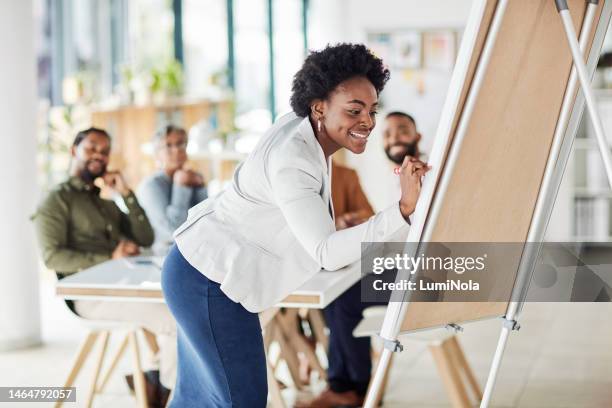 creative black woman, meeting and writing on flipchart for team building, coaching or activity at office. happy african american female in presentation using board to write idea or faq for startup - team building stock pictures, royalty-free photos & images