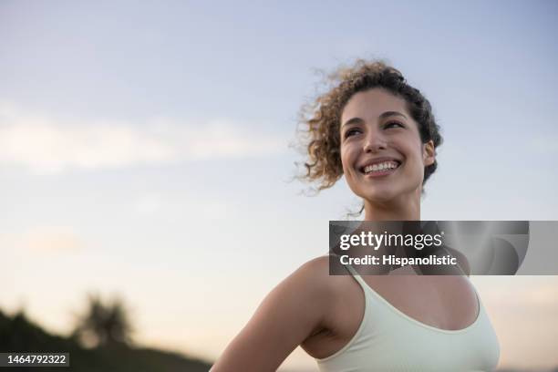 bella donna in forma che sorride alla spiaggia - abbigliamento sportivo foto e immagini stock