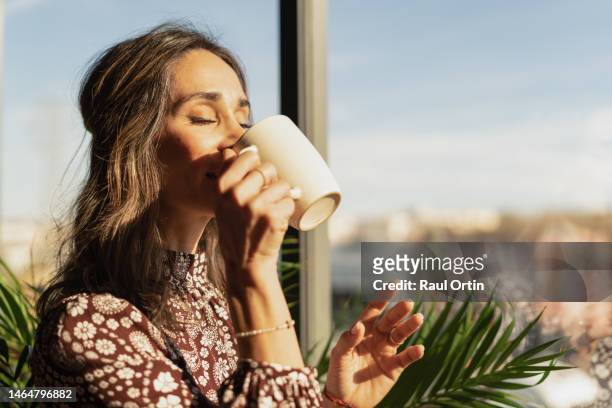 closeup portrait of woman drinking coffee in the morning at home - kaffe dryck bildbanksfoton och bilder