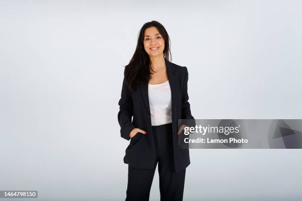 plano medio de una mujer de negocios segura y despreocupada mirando a la cámara y sonriendo alegremente en una sesión de fotos de estudio - toma mediana fotografías e imágenes de stock