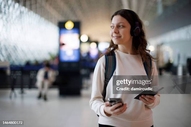 happy and excited teenage girl with headphones at the airport - study abroad stock pictures, royalty-free photos & images