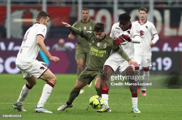 Brahim Díaz of AC Milan is challenged by Wilfried Singo of Torino during the Serie A match between AC MIlan and Torino FC at Stadio Giuseppe Meazza...