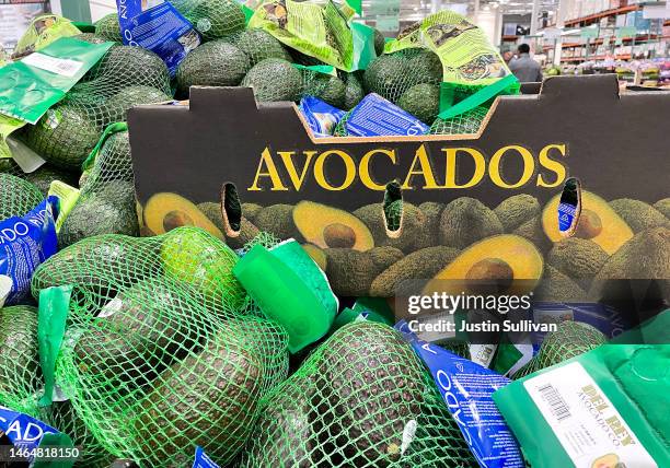 Bags of avocados are displayed on a shelf at a Costco store on February 10, 2023 in Novato, California. Super Bowl fans are seeing lower prices of...