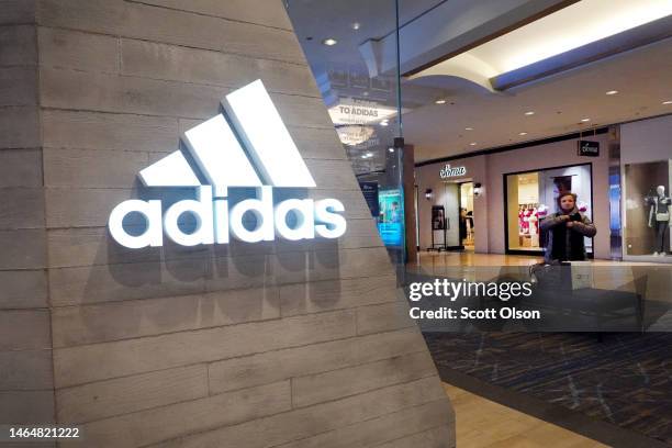 Sign marks the location of an Adidas store inside of a shopping mall on February 10, 2023 in Chicago, Illinois. Adidas is expecting to report a loss...