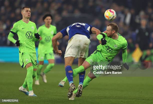 Maximilian Arnold of Wolfsburg is challenged by Michael Frey of Schalke during the Bundesliga match between FC Schalke 04 and VfL Wolfsburg at...