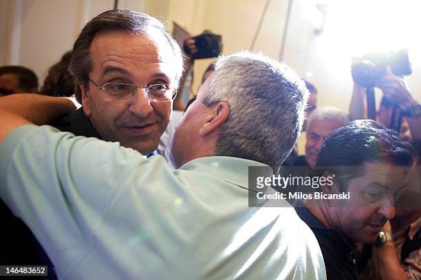 Leader of the New Democracy conservative party Antonis Samaras is embraced as he arrives for a press conference on June 17, 2012 in Athens, Greece....