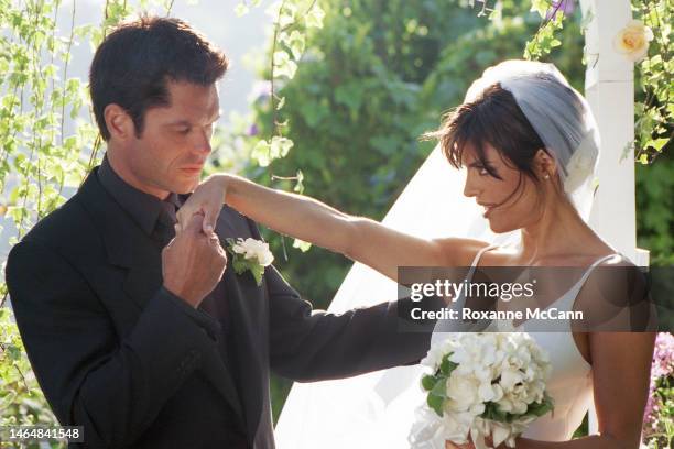 Actor Harry Hamlin kisses the hand of Lisa Rinna a in their garden where they were married on March 29, 1997 in Beverly Hills, California.