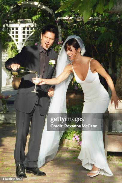 Actor Harry Hamlin pours a glass of Dom Perignon for wife Lisa Rinna in their garden where they were married on March 29, 1997 in Beverly Hills,...