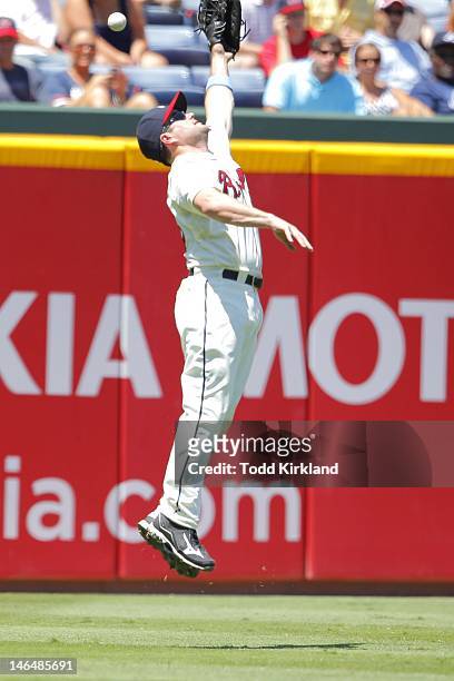 Matt Diaz of the Atlanta Braves leaps for the ball as it tips off his glove during the interleague game against the Baltimore Orioles at Turner Field...