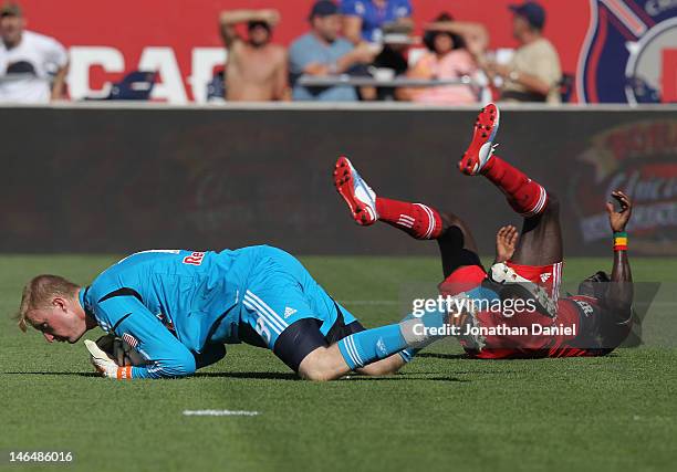 Ryan Meara of the New York Red Bulls makes a save against Dominic Oduro of the Chicago Fire who lands on his back during an MLS match at Toyota Park...
