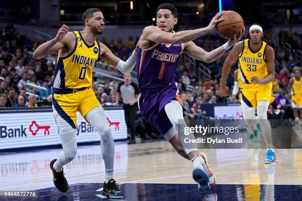 Devin Booker of the Phoenix Suns dribbles the ball while being guarded by Tyrese Haliburton of the Indiana Pacers in the first quarter of the game at...