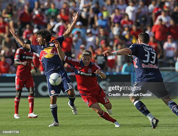 Logan Pause of the Chicago Fire pushes the ball between a complaining Mehdi Ballouchy and Kenny Cooper of the New York Red Bulls during an MLS match...