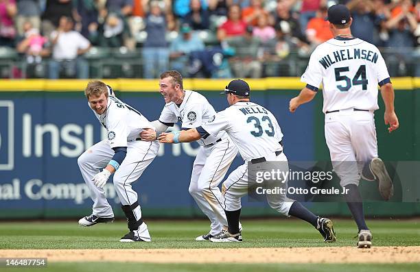 Justin Smoak of the Seattle Mariners is mobbed by teammates after he hit a game winning single to defeat the San Francisco Giants 2-1 at Safeco Field...