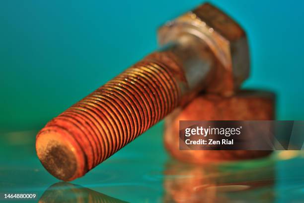 rusty nut and bolt fastener on teal background - nut fastener - fotografias e filmes do acervo