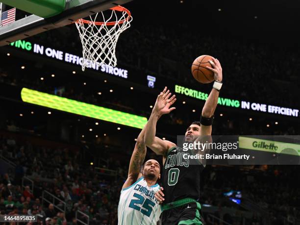 Jayson Tatum of the Boston Celtics attempts a layup in front of P.J. Washington of the Charlotte Hornets in the third quarter of the game at the TD...