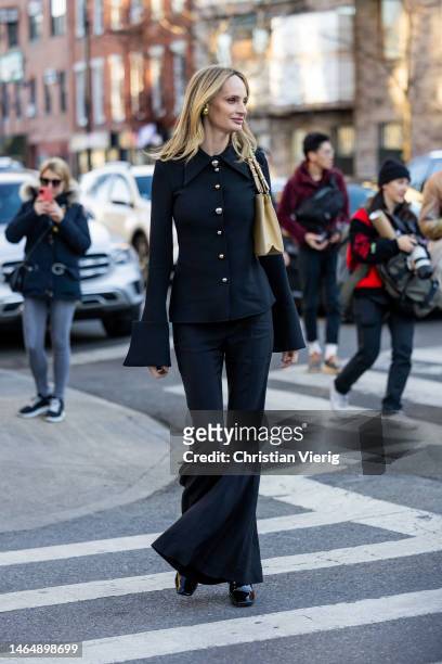 Lauren Santo Domingo wears black flared sleeves button up jacket, flared pants, beige bag outside Rodarte during New York Fashion Week on February...