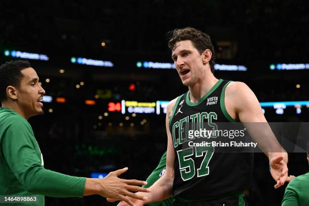 Mike Muscala of the Boston Celtics high-fives Malcolm Brogdon during the fourth quarter of a game against the Charlotte Hornets at the TD Garden on...