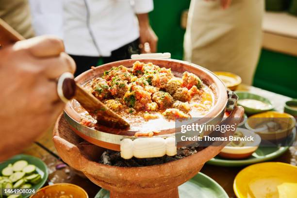 close up shot of man stirring tajine during moroccan cooking class - marrakech spice stock pictures, royalty-free photos & images