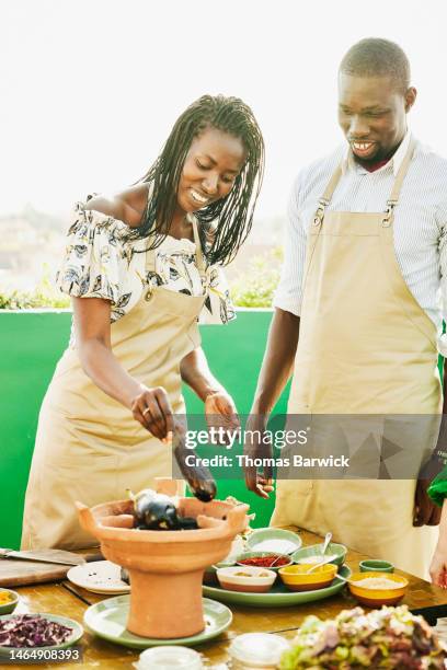 medium shot friends roasting eggplant on charcoal during cooking class - marrakech spice stock pictures, royalty-free photos & images