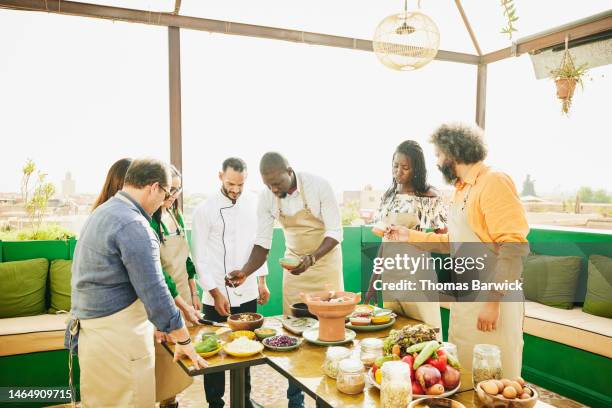 medium shot of friends taking rooftop cooking class while on vacation - chef leader - fotografias e filmes do acervo