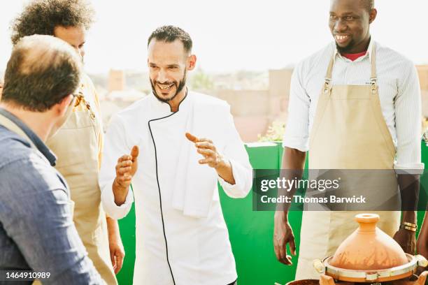 medium shot chef teaching moroccan cooking class to group of friends - chef leader - fotografias e filmes do acervo