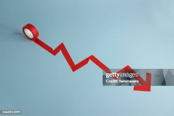 conceptual growth chart arrow moving down with adhesive tape still life. - arrow down stock pictures, royalty-free photos & images
