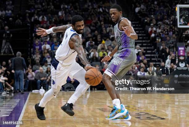 Kyrie Irving of the Dallas Mavericks dribbling the ball while being defended by De'Aaron Fox of the Sacramento Kings during the fourth quarter at...