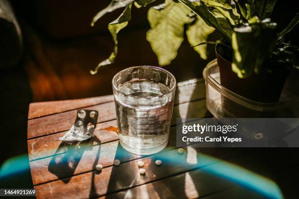 glass of water and pills and blister with hard shadows - opioid stock pictures, royalty-free photos & images