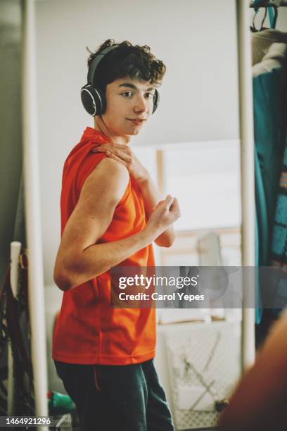 teenager boy, showing his muscles at the mirror - skinny teen fotografías e imágenes de stock