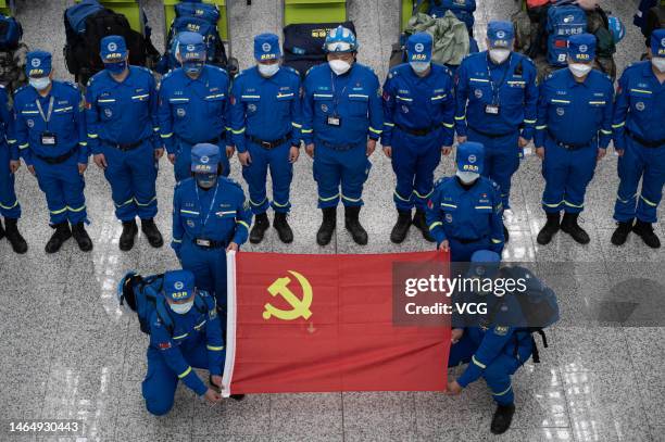 Members of Blue Sky Rescue team pose with a flag of the Communist Party of China at Guangzhou Baiyun International Airport before departing for...