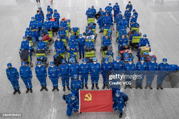 Members of Blue Sky Rescue team pose with a flag of the Communist Party of China at Guangzhou Baiyun International Airport before departing for...