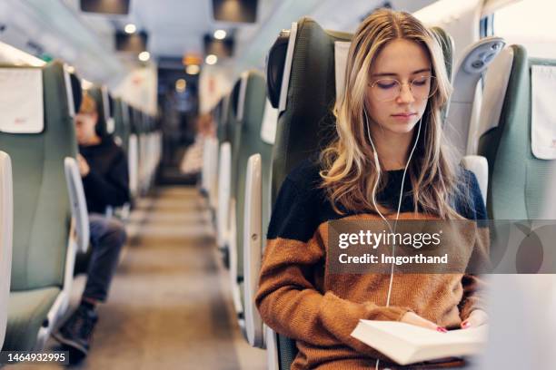 adolescente viajando en tren moderno - vagón fotografías e imágenes de stock
