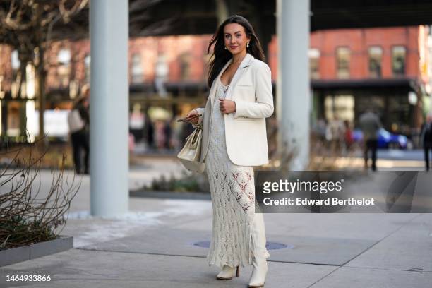 Kendall Becker wears gold and white pearls pendant earrings, a white blazer jacket, a white tank-top short dress, a white latte braided cut-out print...